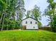 Backyard view showcasing the home's exterior and a large green lawn surrounded by mature trees at 5728 Williams Rd, Norcross, GA 30093