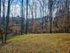 Spacious backyard with mature trees creating a private and serene outdoor space with neighboring houses at 5728 Williams Rd, Norcross, GA 30093