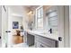 Bright bathroom featuring double sinks, a window for natural light, and view to the adjacent office at 5728 Williams Rd, Norcross, GA 30093