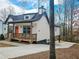 Side view of an elegant home featuring a bright orange door and a spacious wooden deck for outdoor living at 5728 Williams Rd, Norcross, GA 30093