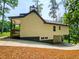 Side view of a two-story home with a garage and a covered deck, surrounded by lush greenery at 5728 Williams Rd, Norcross, GA 30093