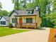 Charming new construction with inviting front porch and vibrant orange door at 5728 Williams Rd, Norcross, GA 30093