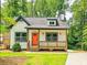 Charming cottage-style home featuring a welcoming front porch and a vibrant orange front door at 5728 Williams Rd, Norcross, GA 30093