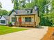Inviting cottage-style home featuring a lovely front porch and ample parking on a paved driveway at 5728 Williams Rd, Norcross, GA 30093