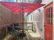 Charming wooden deck with a table and chairs, shaded by a red umbrella, next to the home's bright orange door at 5728 Williams Rd, Norcross, GA 30093