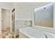 Bright bathroom with tub, window, and view into the tiled stand-up shower at 1245 Ladd Sw St, Atlanta, GA 30310