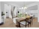 Bright dining room features a dark wood table set for dinner, open floor plan, staircase at 145 Millennial Ct, Lawrenceville, GA 30045