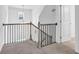 Hallway features a carpet floor, wrought iron railing, and a window for natural light at 145 Millennial Ct, Lawrenceville, GA 30045