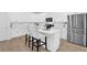 Charming kitchen offers white cabinets, stainless steel appliances, and seating at the island at 145 Millennial Ct, Lawrenceville, GA 30045