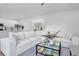 Bright living room featuring hardwood floors, a comfortable white sofa, and open access to the kitchen at 145 Millennial Ct, Lawrenceville, GA 30045