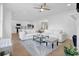 Open-concept living room with hardwood floors, a white sofa, and seamless access to the kitchen at 145 Millennial Ct, Lawrenceville, GA 30045