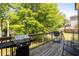 Cozy back deck features a stainless steel grill, wood flooring, with outdoor seating overlooking the backyard at 2889 Carrousel Ct, Stone Mountain, GA 30087