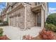 A detailed view of the front exterior of a two-story home, showcasing the brickwork, landscaping, and two-car garage at 5621 Cobblestone Creek Ave # 14, Mableton, GA 30126