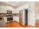 Modern kitchen featuring stainless steel appliances, granite countertops, white cabinets, and hardwood floors at 5621 Cobblestone Creek Ave # 14, Mableton, GA 30126