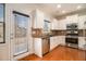 Bright kitchen featuring white cabinets, stainless steel appliances, granite countertops, and a door leading to the outside at 5621 Cobblestone Creek Ave # 14, Mableton, GA 30126