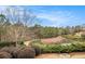 A small pond near a wooded area is lined with green shrubs and tall trees at 5621 Cobblestone Creek Ave # 14, Mableton, GA 30126