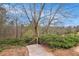 Steps lead down a stone walkway lined by shrubs and deciduous trees at 5621 Cobblestone Creek Ave # 14, Mableton, GA 30126
