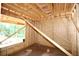 Interior framing of home with wood beams, stud walls, and window opening looking into wooded yard at 578 Price Rd, Carrollton, GA 30116