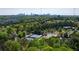 Aerial view of the tennis courts and surrounding trees with the city skyline of Atlanta in the distance at 1174 City Park Ln, Decatur, GA 30033