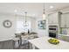 Dining area featuring a modern chandelier, a wooden table with white chairs, and hardwood floors at 1174 City Park Ln, Decatur, GA 30033