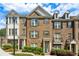 Charming brick townhome with gabled roof, neutral shutters, and lush landscaping at 1174 City Park Ln, Decatur, GA 30033
