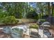 Landscaped backyard with a stone patio, planters, and a grill, creating an inviting outdoor entertaining area at 2180 Howell Mill Nw Rd, Atlanta, GA 30318