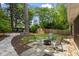 Backyard with mature trees, stone patio, and a fire pit, ideal for outdoor entertaining and relaxation at 2180 Howell Mill Nw Rd, Atlanta, GA 30318