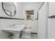 Bright bathroom featuring a pedestal sink, black and white tile flooring, and a window for natural light at 2180 Howell Mill Nw Rd, Atlanta, GA 30318