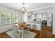 Charming dining area adjacent to a modern kitchen with white cabinets, stainless appliances, and hardwood floors at 2180 Howell Mill Nw Rd, Atlanta, GA 30318