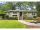 Charming brick home with landscaped front yard, stone pathway, and stairs leading to the front door at 2180 Howell Mill Nw Rd, Atlanta, GA 30318