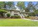 Charming single-story house featuring a lush front yard with stone pathway, flower beds, and mature trees at 2180 Howell Mill Nw Rd, Atlanta, GA 30318