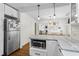 Modern kitchen with stainless steel appliances, white cabinets, and hardwood floors, transitioning to dining area at 2180 Howell Mill Nw Rd, Atlanta, GA 30318