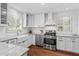 Well-lit kitchen featuring white cabinets, subway tile backsplash, stainless steel appliances, and a farmhouse sink at 2180 Howell Mill Nw Rd, Atlanta, GA 30318