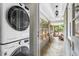 Conveniently located laundry area with stacked washer/dryer adjacent to a tiled sunroom at 2180 Howell Mill Nw Rd, Atlanta, GA 30318