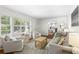 Sunlit living room with hardwood floors, neutral furniture, and an adjacent doorway to the kitchen at 2180 Howell Mill Nw Rd, Atlanta, GA 30318