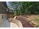 Landscaped backyard with retaining wall, and plantings around the house at 2445 Kings Point Dr, Dunwoody, GA 30338
