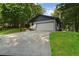 View of a large driveway, lawn, garage and partial view of the house at 2445 Kings Point Dr, Dunwoody, GA 30338