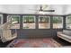 Screened porch featuring 4 large windows overlooking a lush yard, a ceiling fan and patio furniture at 2445 Kings Point Dr, Dunwoody, GA 30338
