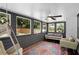 Screened porch featuring 4 large windows overlooking a lush yard, a ceiling fan and patio furniture at 2445 Kings Point Dr, Dunwoody, GA 30338