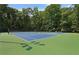 Community tennis courts for recreational play surrounded by mature trees at 2445 Kings Point Dr, Dunwoody, GA 30338