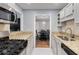 Galley kitchen boasting granite countertops and stainless steel appliances and view to the dining room at 303 Gettysburg Pl, Atlanta, GA 30350