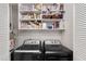 Functional laundry area with modern washer and dryer units and ample shelving at 303 Gettysburg Pl, Atlanta, GA 30350