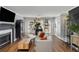 Bright living room features a fireplace, hardwood floors, lots of plants, and large windows for plenty of light at 303 Gettysburg Pl, Atlanta, GA 30350