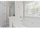 Bright bathroom features a soaking tub beneath a window and a glass-enclosed shower at 3234 Baymount Way, Lawrenceville, GA 30043
