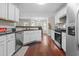 A bright kitchen featuring white cabinets, stainless steel appliances, and a breakfast nook with bay windows at 3234 Baymount Way, Lawrenceville, GA 30043