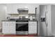 Kitchen with stainless steel appliances, white cabinets, and black countertops at 3234 Baymount Way, Lawrenceville, GA 30043