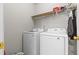Bright laundry room features a side-by-side washer and dryer and wire shelving for convenient storage at 3234 Baymount Way, Lawrenceville, GA 30043