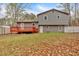 Backyard of a two-story gray home with a red wooden deck and a storage shed in view at 3640 Silver Leaf Sw Ln, Marietta, GA 30008
