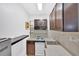 This is a kitchen with stainless sink, gas range, dark cabinets and light colored backsplash at 3640 Silver Leaf Sw Ln, Marietta, GA 30008