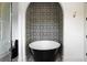 Elegant bathroom features a black soaking tub and decorative tiling in the bath niche at 11277 Serenbe Ln, Chattahoochee Hills, GA 30268